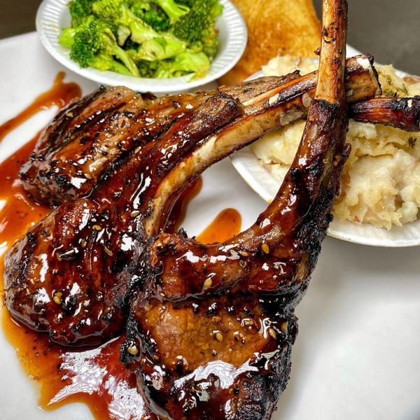 Shiny glazed lamb chops, mashed potatoes, steamed broccoli, and golden toast on a white plate.
