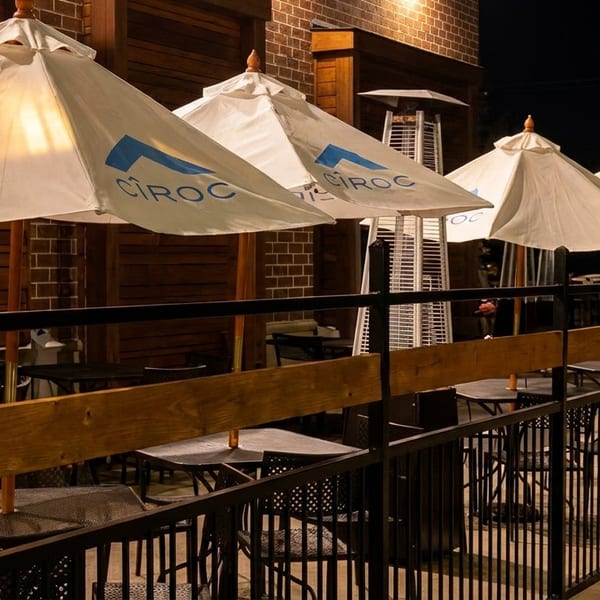 Outdoor patio at night with white umbrellas, Ciroc logos, and patio heaters.